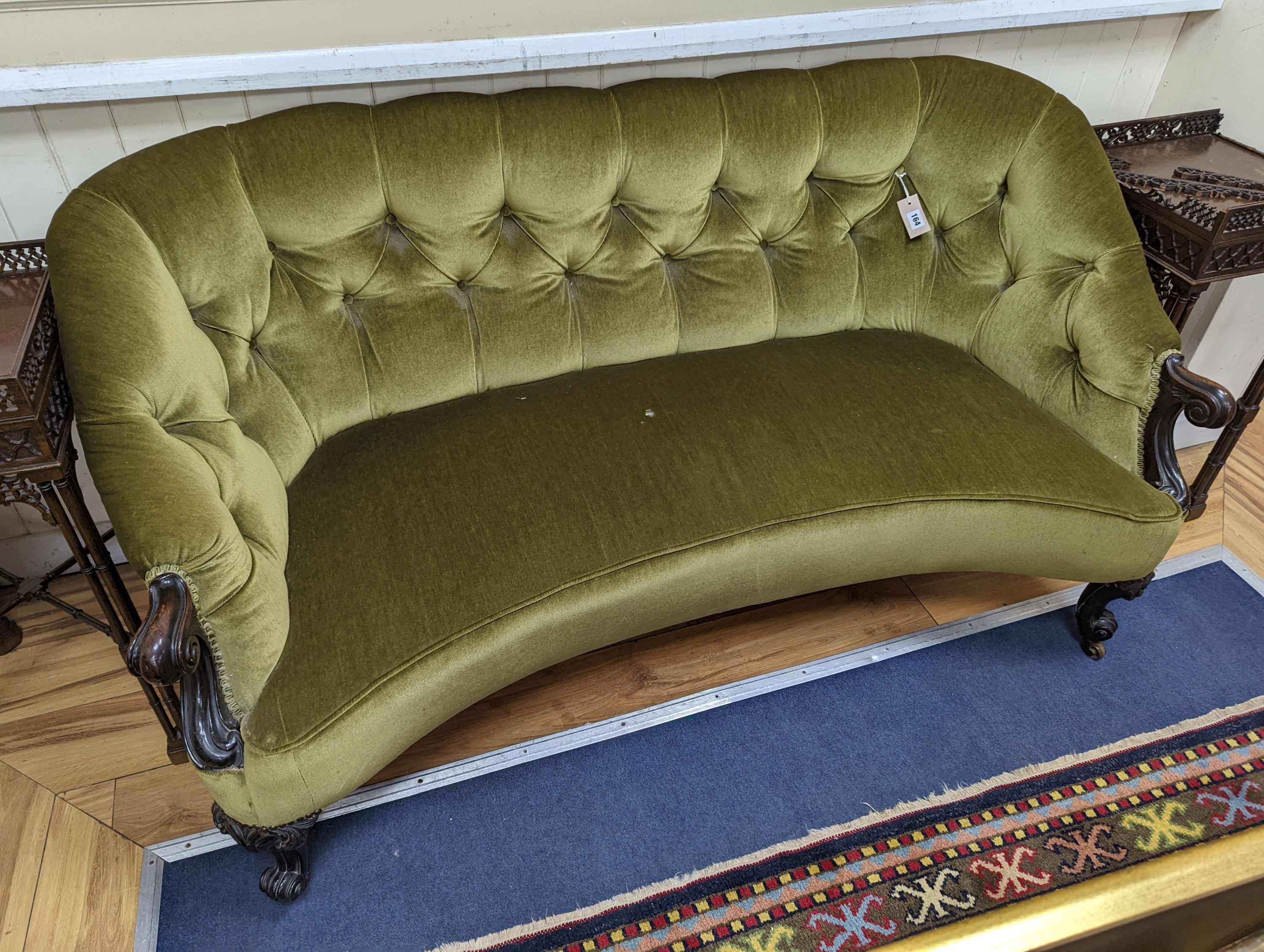 An early Victorian rosewood concave fronted two seat settee upholstered in buttoned green dralon, length 156cm, depth 77cm, height 80cm